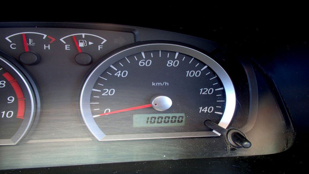 Imagem mostra painel do carro com odômetro mostrando 100.000 km de quilometragem