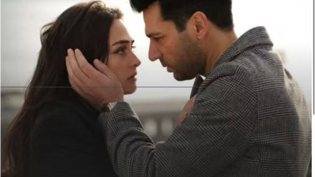 Duas pessoas se encaram com emoção intensa; uma segura o rosto da outra com as mãos, em um cenário urbano e frio.